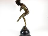 bronze statue of a man on a pedestal with a clock in the background