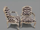 pair of zebra print chairs on a grey background