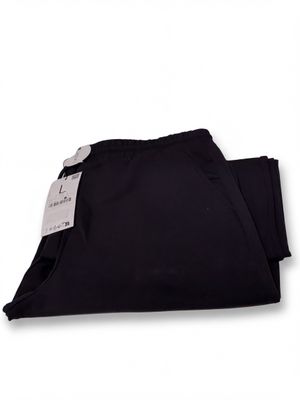 the black pants are folded up on a white surface