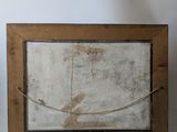 an old wooden frame with a picture of a bird on it