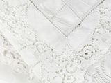 a close up of a white table cloth with lace on it