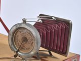 a red suitcase with a clock and a camera in it