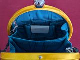 a yellow purse that is sitting on a red carpet