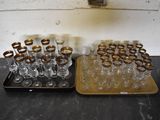 two trays of empty wine glasses on a table