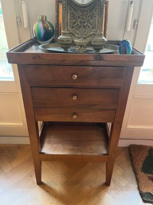 une petite table en bois sur laquelle est posée une horloge