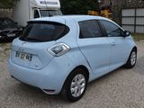 a small blue car parked in front of a trailer