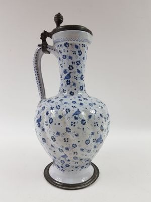un vase bleu et blanc muni d'une anse et posé sur un socle