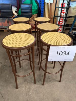 quatre tabourets en bois avec des assises en osier dans un magasin