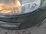 a close up of a car ' s headlight on the street