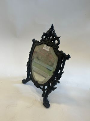 an antique mirror with a black frame sitting on top of a white surface