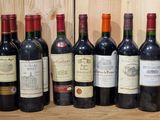 several bottles of wine are lined up on a wooden shelf