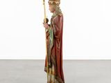 a statue of a man in a crown and robe holding a staff
