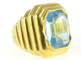an image of a gold ring with a blue topaz stone