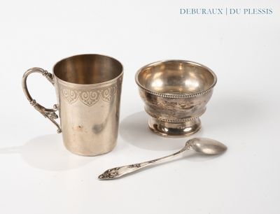 une tasse et une cuillère en argent posées l'une à côté de l'autre sur une table