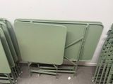 several green folding tables and chairs in a room with carpet
