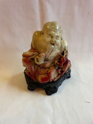 une figurine représentant un homme assis sur un rocher