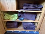 many folded towels on a shelf in a cabinet