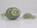 two pieces of green jade on a white surface
