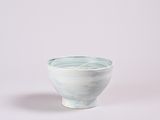 a small white bowl with a blue glaze on it