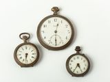 trois horloges posées sur une surface blanche