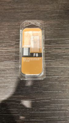 un récipient en plastique posé sur une table, contenant un téléphone jaune