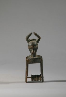 deux petites sculptures en bois représentant une femme et un chat, posées sur un tabouret