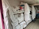 Des serviettes sont empilées sur une étagère dans une pièce aux murs carrelés