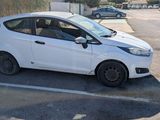 a small white car that is parked in a parking lot