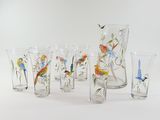 seven glasses and a pitcher with birds painted on them