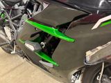 a close up of a green motorcycle parked in a garage