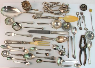 beaucoup d'argenterie sur une table, avec des cuillères et des couteaux-cuillères