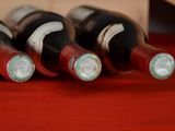several bottles of wine are lined up on a red table