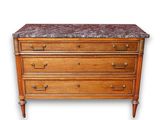 a wooden chest of drawers with a marble top
