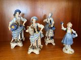 cinq figurines représentant des femmes vêtues de bleu et de blanc