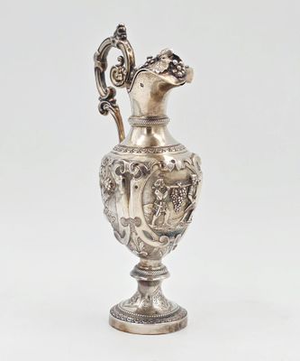 un vase ancien en métal argenté orné d'un oiseau