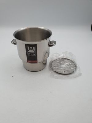 une casserole en argent et un sac en plastique posés sur une table blanche