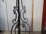 a tall iron pole with a clock on top of it