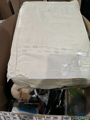 une boîte en carton contenant un matelas et une peluche