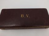 an old brown leather case with the initials b v on it