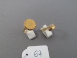 two rings and a gold coin sitting on a table