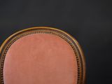 a close up of a chair with a pink upholstered seat