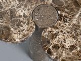 a close up of a marble table with a vase on it