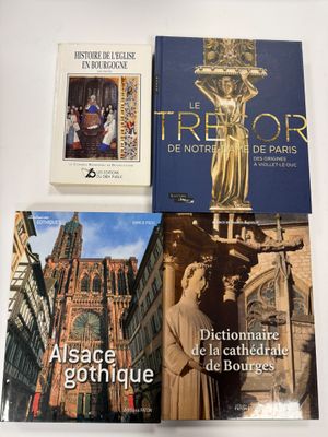trois livres posés sur une table, avec des photos de bâtiments et d'une statue