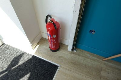 a red fire extinguisher next to a blue door