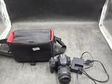un appareil photo et un sac posés par terre l'un à côté de l'autre