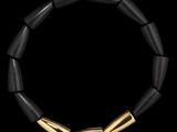 un gros plan d'un bracelet noir et doré sur fond noir