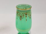a green vase with a gold decoration on it