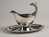 an antique silver plate with a peacock on it