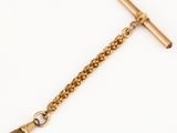 a close up of a gold chain with a cross on it