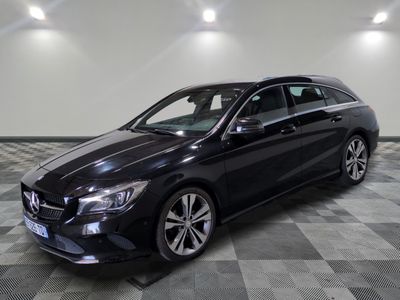 a black mercedes cla parked in a garage with a checkered floor